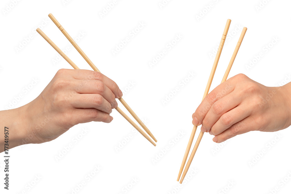 Female hand holding wooden sushi chopsticks isolated on white background.