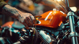 Capturing the intense focus of a mechanic's hands as they delicately measure the oil of a brightly colored orange motorcycle