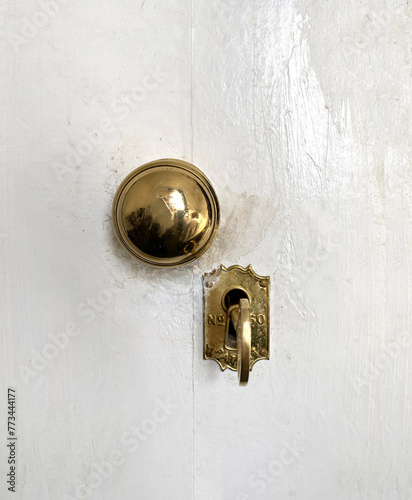 Antique door lock. Golden door handle with antique gold-engraved crest. Ancient lock with key. Old metal key in the keyhole.