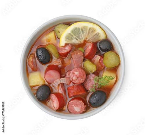Meat solyanka soup with thin dry smoked sausages in bowl isolated on white, top view