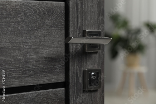 Open wooden door with metal handle, closeup photo