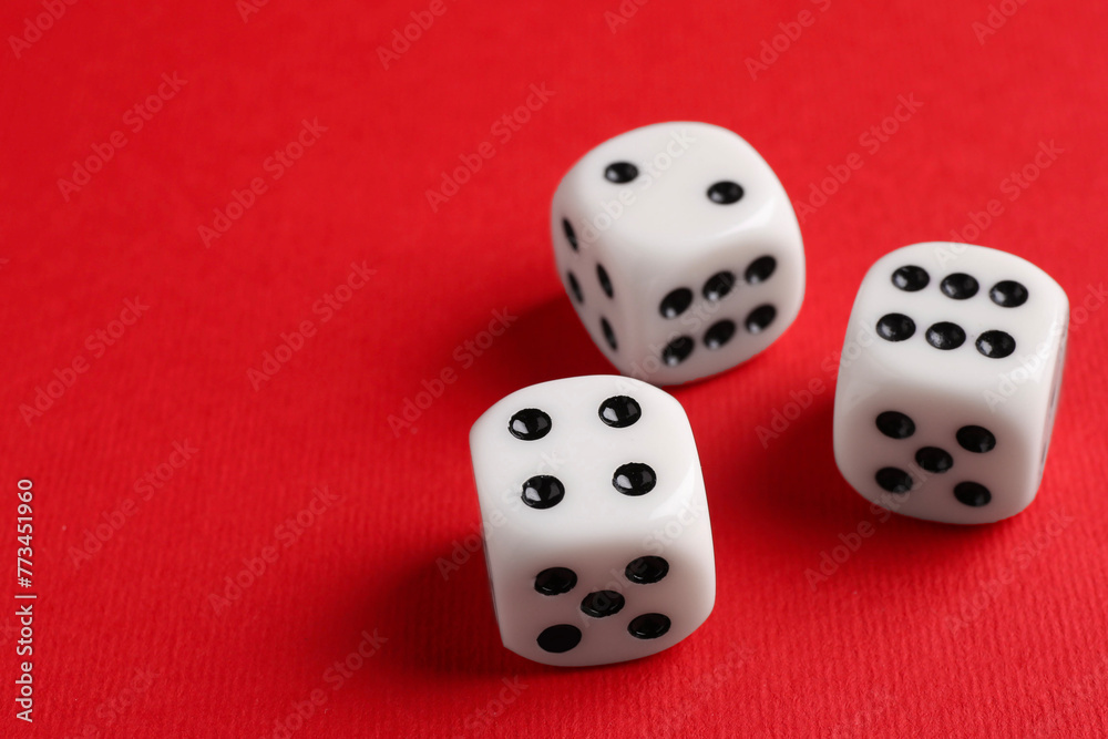 Three white game dices on red background, closeup Three white game dices on red background, closeup