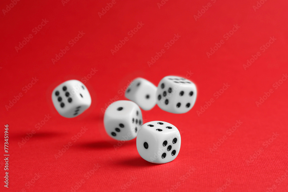 Many white game dices falling on red background Many white game dices falling on red background