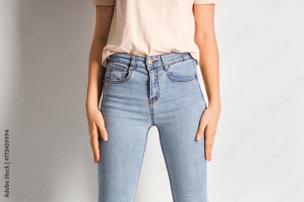 Young woman in stylish jeans pants on white background - obrazy, fototapety, plakaty 