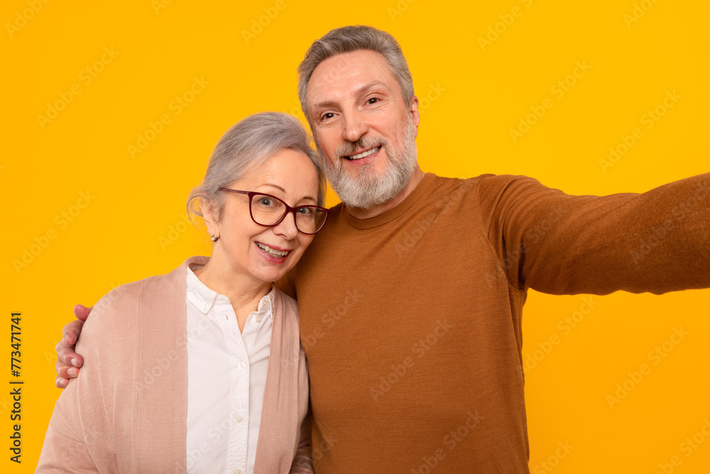 happy european senior man embracing wife posing for selfie, studio happy european senior man embracing wife posing for selfie, studio