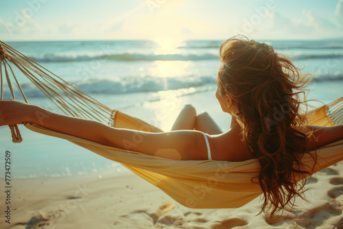 woman relaxing on the beach in a hammock photo