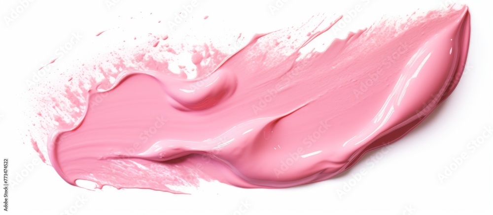 A close-up view of a vibrant pink liquid being poured onto a clean white surface, creating a colorful and artistic display