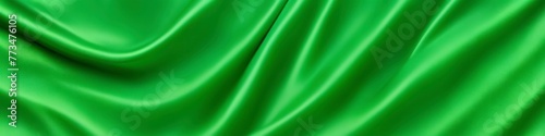 Light green panoramic silk fabric background in bright pastel colors with blurred satin wavy texture. 