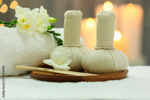 Beautiful composition with different spa products and flowers on white towel against blurred background, closeup