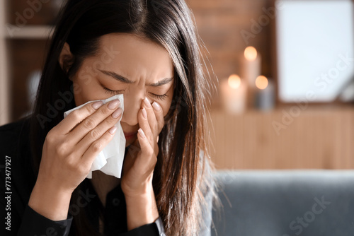 Grieving young Asian woman crying at funeral, closeup
