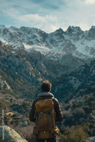 Wallpaper Mural A man standing on top of a mountain with a backpack, suitable for adventure and travel concepts Torontodigital.ca