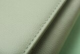 Green leather with seam on table, closeup