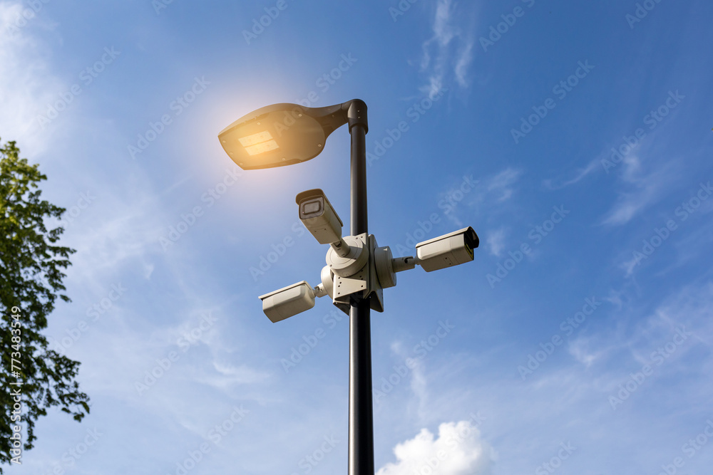 Modern lamppost and CCTV cameras in public park. Public space safety systems Modern lamppost and CCTV cameras in public park. Public space safety systems