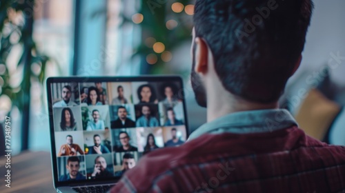 A man sitting in front of a laptop with a group of people displayed on the screen. Suitable for business and technology concepts photo
