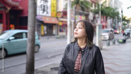 Slow-motion video of Okinawan women in their 20s in winter clothes walking on Kokusai Street in Naha City, Okinawa Prefecture 沖縄県那覇市の国際通りを歩く冬服の20代の沖縄県民女性のスローモーション映像 photo