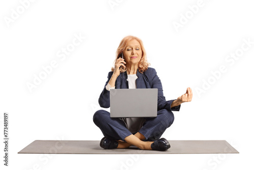 Businesswoman practicing yoga, using a smartphone and a laptop computer