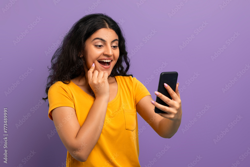 Enthusiastic woman with phone on violet Enthusiastic woman with phone on violet