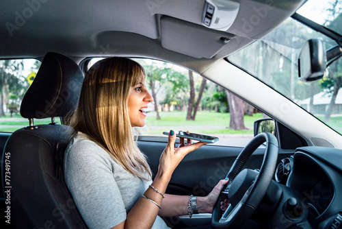 Woman driving and sending a voice message with mobile phone
