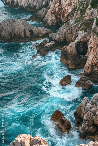 A person sitting on a rock overlooking the ocean. Suitable for travel and relaxation themes