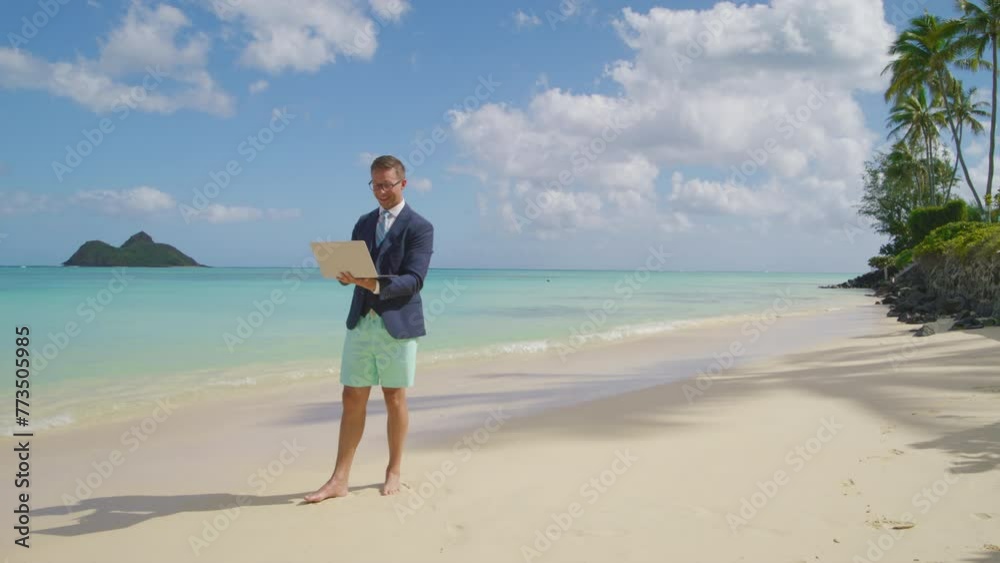 Caucasian businessman in jacket, white shirt and beach shorts making a deal while having video chat, standing barefoot on the beach of the Hawaii island. High quality 4k footage Caucasian businessman in jacket, white shirt and beach shorts making a deal while having video chat, standing barefoot on the beach of the Hawaii island. High quality 4k footage