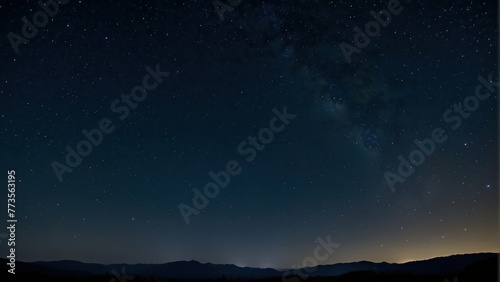 Starry night sky over a silhouette of hills