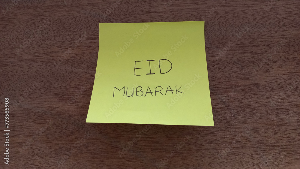 EID MUBARAK Sticky Note on Wooden Background EID MUBARAK Sticky Note on Wooden Background