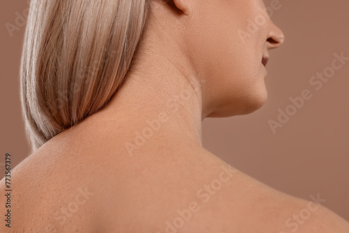Back view of woman with healthy skin on beige background, closeup