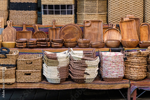Stack of handmade rattan baskets on a shelf sold on a market stall © Tatty