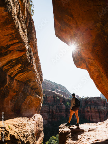 Secret Subway Cave Boynton Canyon Sedona solo female hiker staring off into canyon with sunstar.