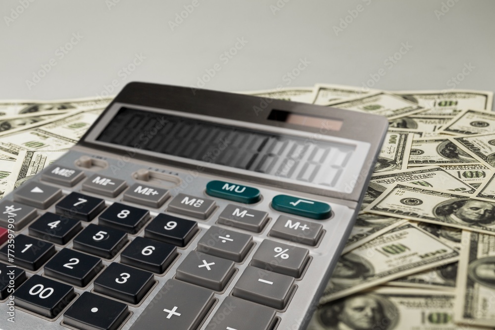 Calculator with 2024 tax concept and pile of money Calculator with 2024 tax concept and pile of money