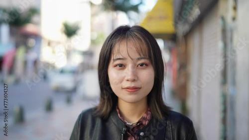 Slow-motion video of the face of an Okinawan woman in her 20s in winter clothes on Kokusai Street in Naha City, Okinawa Prefecture 沖縄県那覇市の国際通りの冬服の20代の沖縄県民女性の顔のアップのスローモーション映像 photo