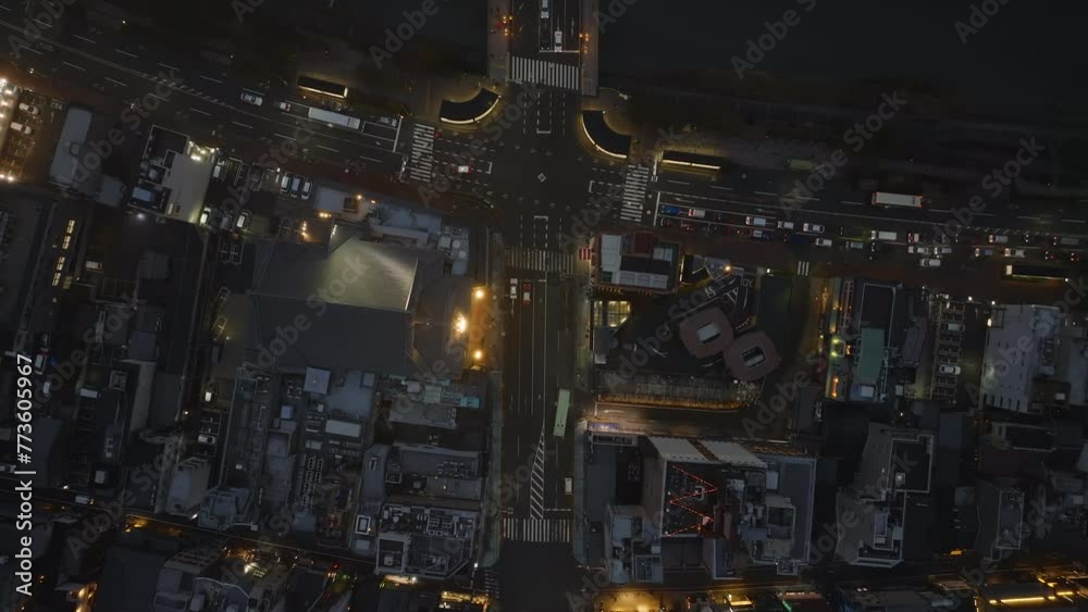 Fly above road intersection in evening city. Streets illuminated by streetlights, cars standing at traffic lights. Kyoto, Japan Fly above road intersection in evening city. Streets illuminated by streetlights, cars standing at traffic lights. Kyoto, Japan
