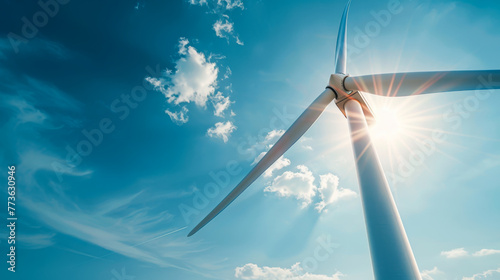 A wind turbine is standing tall in the sky, with the sun shining brightly on it. Concept of energy and power, as the wind turbine harnesses the sun's energy to generate electricity