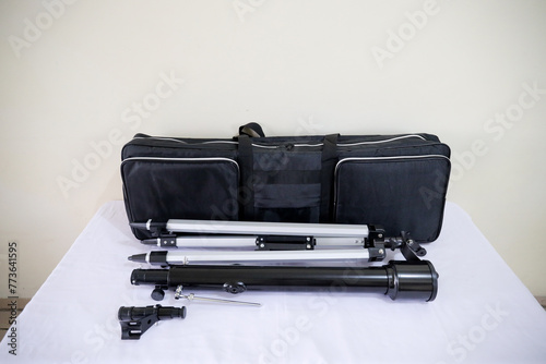 Telescope bag with accessories on white table for nature observe traveler.	
