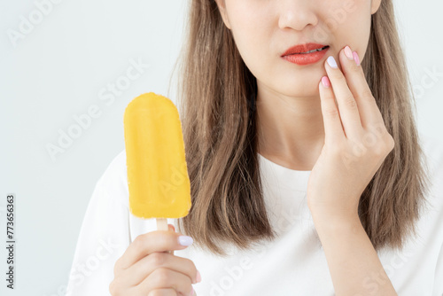 Foto Asian woman feel sensitive teeth after eating ice cream, female suffer tooth, de