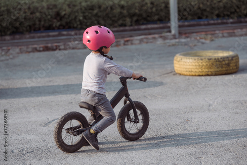 Photo of Asian Child pratice riding bicycle in the park outdoor 