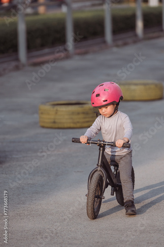 Portrait of Asian child with a pink helmet riding bike 