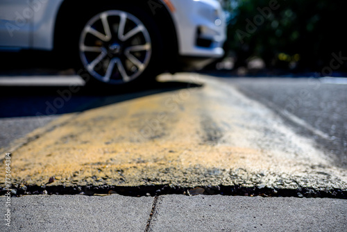 Canvas Print Selective focus on area in front of a speed bump with a car driving over