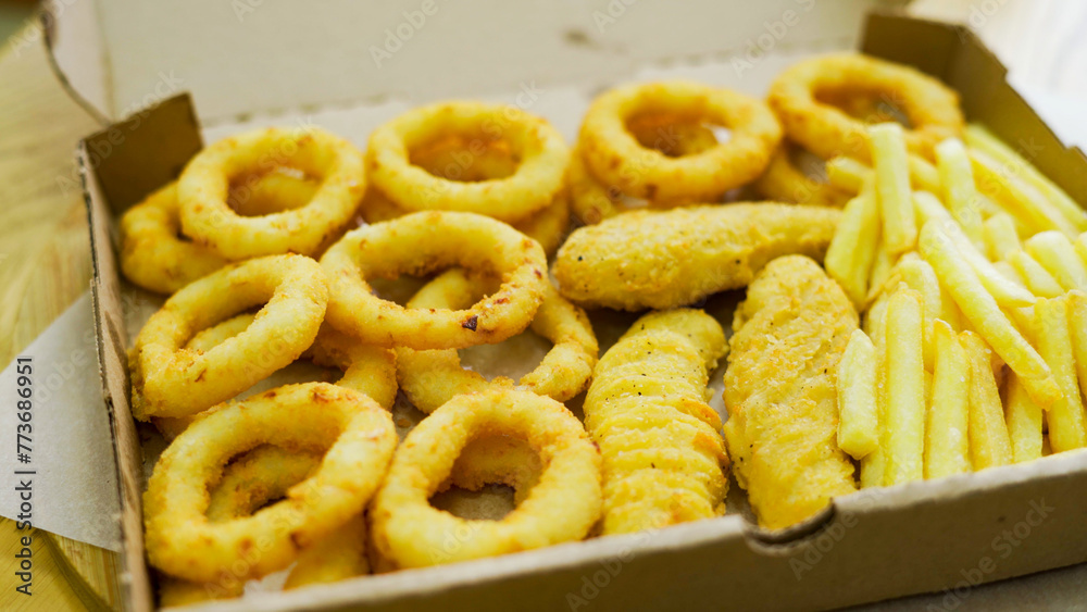 Set of takeaway paper boxes with different fast food, french fries, nuggets, onion rings and different sauces Set of takeaway paper boxes with different fast food, french fries, nuggets, onion rings and different sauces