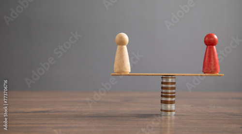 Wooden human figure, coins on the table.