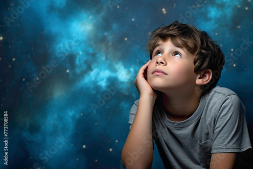 A contemplative kid model lost in thought, against a solid wall of blue background, pondering the mysteries of the universe with wonder.