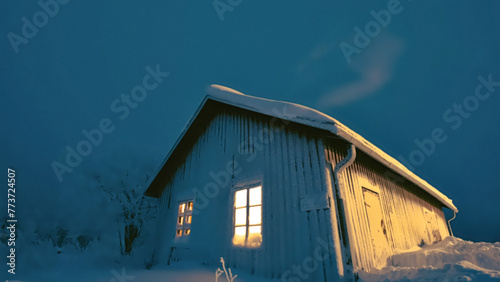 A small cabin on a hill on a in the cold night sky covered with snow, Finland, Dec 2023