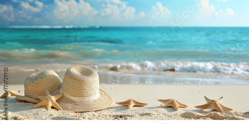 A beach scene with two straw hats and a bunch of stars. The hats and stars are on the sand  and the ocean is in the background. Scene is relaxed and carefree