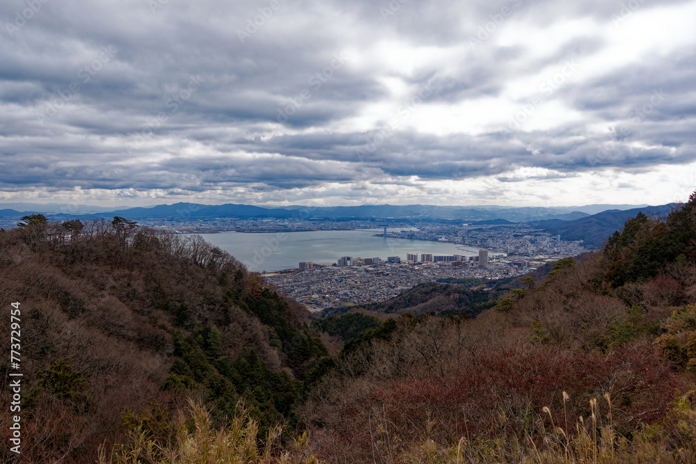 Scenic view from Yumemigaoka View Deck over largest Japanese Lake Biwa with City of Otsu on a cloudy winter day. Photo taken February 2nd, 2024, Yumemigaoka, Kyoto, Japan.