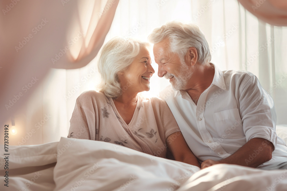 An elderly man and woman are laying together in bed, showcasing love and romance in their relationship An elderly man and woman are laying together in bed, showcasing love and romance in their relationship