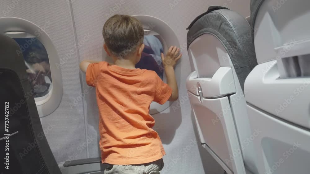 Little kid looking on airplane window during the night flight Little kid looking on airplane window during the night flight