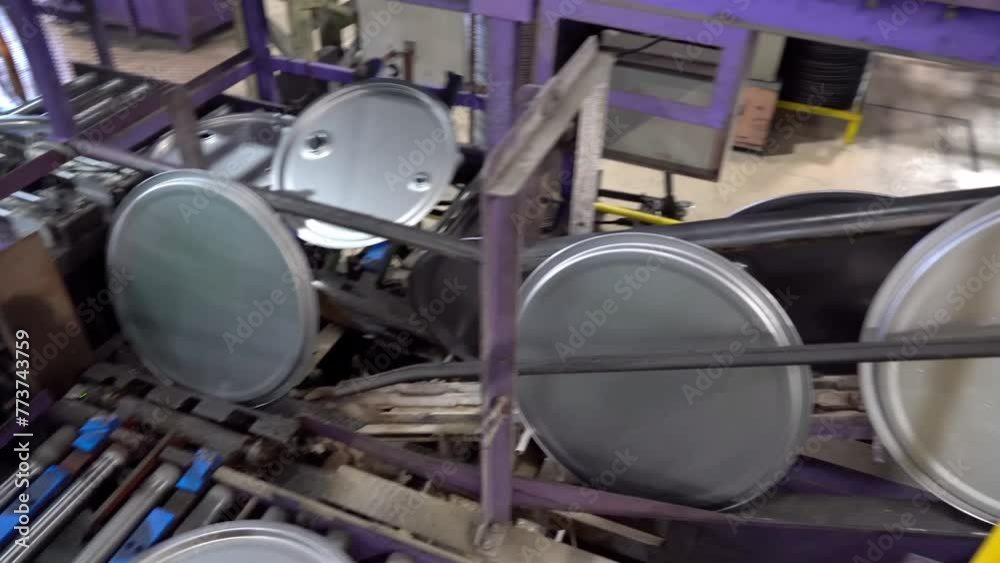Steel drum lids travel steadily on a conveyor for further processing. Steel drum lids travel steadily on a conveyor for further processing.