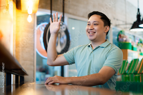 Asian man friendly Greeting at the Modern Cafe photo