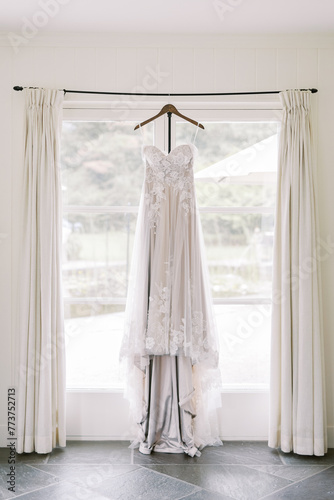 Wedding dress on hanger in bright room