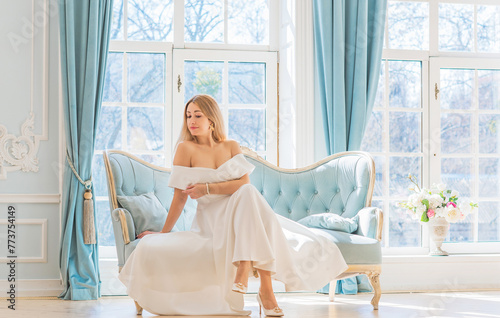 Romantic old money style. Woman wear white midi dress on royal light blue background, fashionable scene. Concept of vintage luxury lifestyle. photo